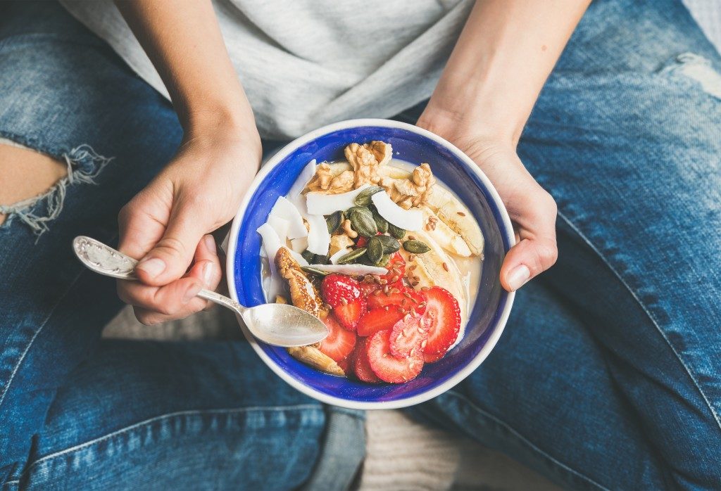 woman eating a healthy breakfast bowl