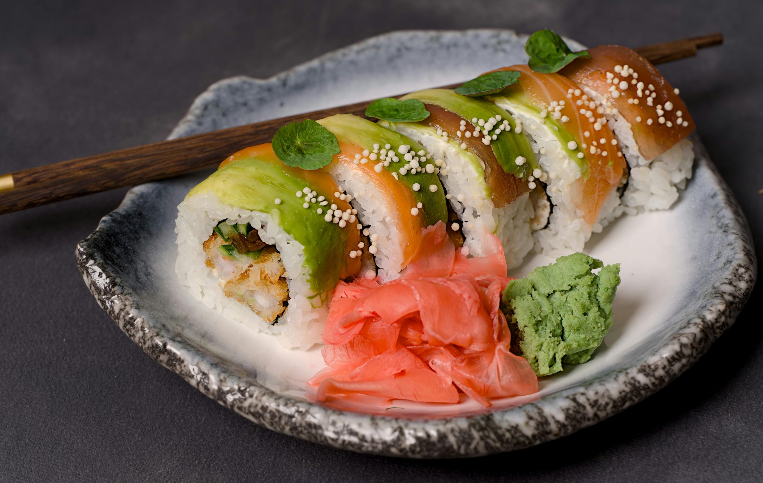 wasabi, gari, and sushi on a ceramic plate